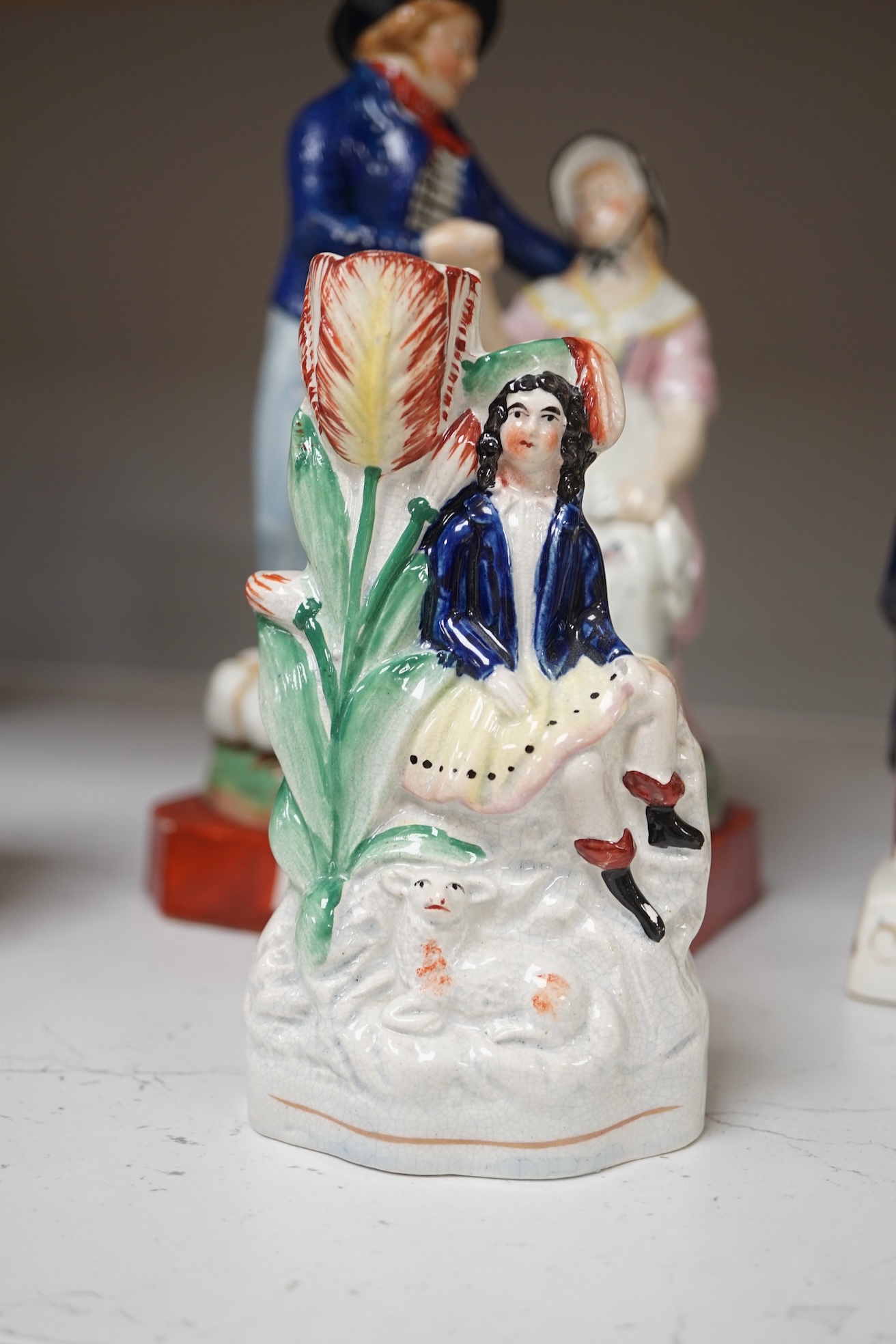 Six mid 19th century Staffordshire figures or groups: a pair titled ‘my grandmother and my grandfather’, a double sided water/gin figure, a pair of figural spill vases and a pearlware group titled ‘Departure’, the talles